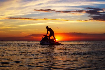 Foto op Canvas silhouette of a man on a jet ski in the sun © Wingedbull