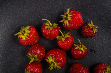 fresh ripe strawberries on black ceramic plate