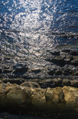 rocky sea shore with pebble beach, waves with foam