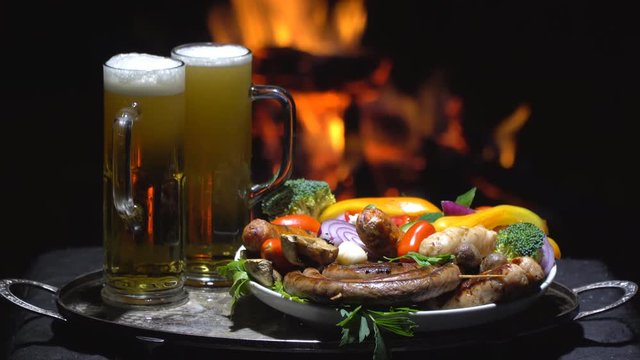 two glasses of beer on the background of fire
