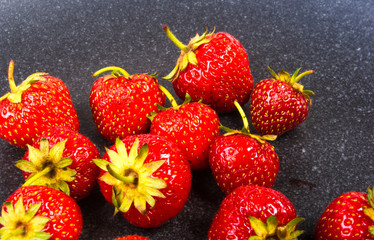 fresh ripe strawberries on black ceramic plate