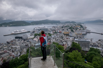 Female hiker looking at city of Alesund from Aksla mountain, Norway.