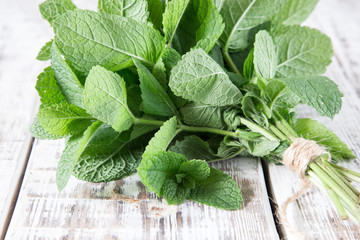 Mint. Bunch of Fresh green organic mint leaf on wooden table closeup. Selective focus.