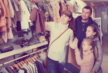 Fototapeta premium Family with children searching clothes for new baby
