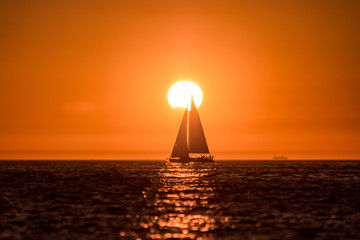 Eclipse au coucher de soleil et voilier