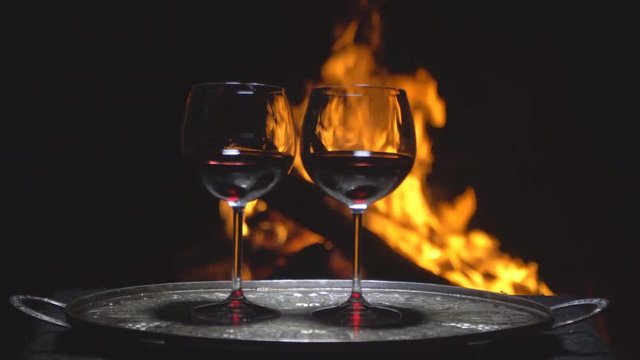 two glasses of wine on the background of fire