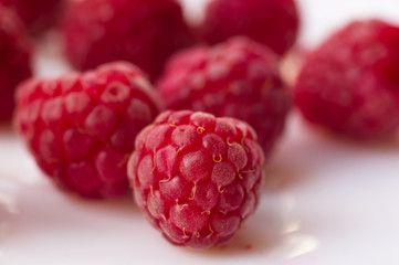 raspberries on a white saucer close up