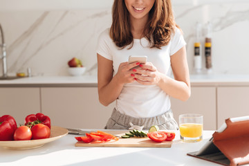Cropped image of a pretty smiling woman using mobile phone
