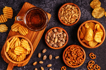 Beer with snacks on stone background.