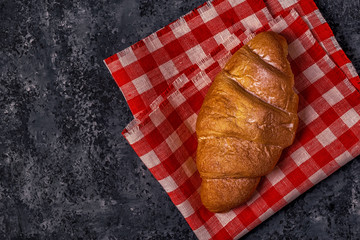 Fresh croissant on dark background.