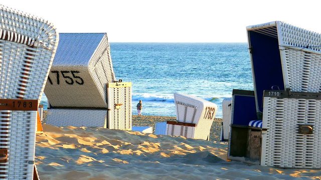 Weisse Strandk&ouml;rbe vor ruhiger Nord See im warmen Sonnenuntergang Licht