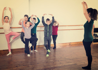 Young ballet dancers exercising in ballroom