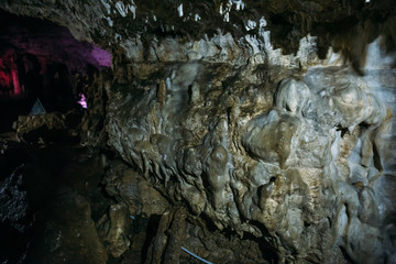 Fototapeta premium Stone wall with outgrowths inside the underground cave