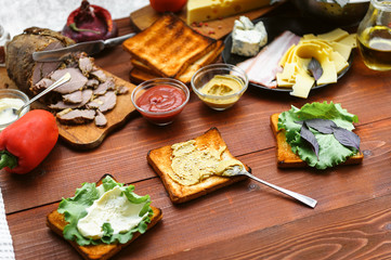 the hostess prepares a sandwich on a wooden table for guests