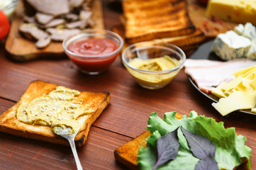 the hostess prepares a sandwich on a wooden table for guests
