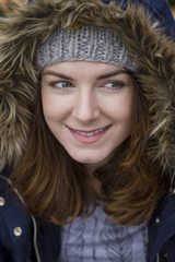 Portrait of a young woman wearing hood in autumn. Soft focus