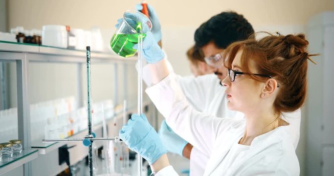 Young students of chemistry working in laboratory