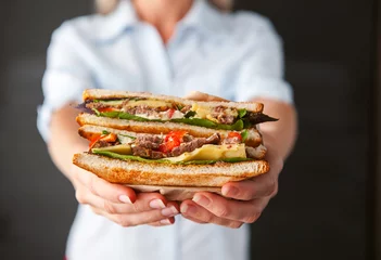 Rolgordijnen sandwich in the hands of a girl © Mikhaylovskiy 
