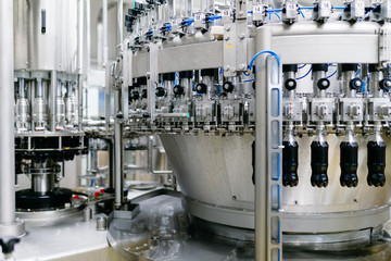 Bottling factory - Black juice bottling line for processing and bottling juice into bottles. Selective focus. 