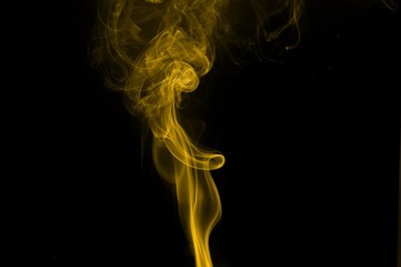 Obraz premium Gold smoke on black background,movement of gold smoke, Abstract gold smoke on black background, gold background,gold ink background,yellow smoke,Glittering gold smoke tail