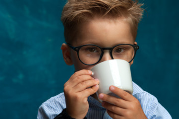 Closeup of child posing with cup of drink.