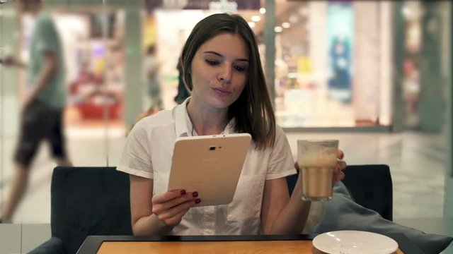 Young businesswoman using tablet computer sitting in cafe

