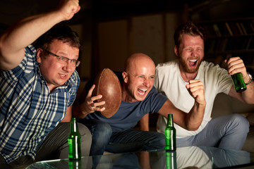 Three friends watching american football game on television
