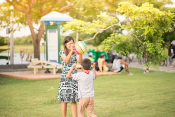 Single mom Mother and son play football together in the park