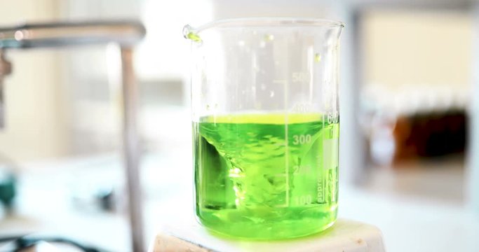 Mechanical stirring, liquid of green color is mixed in a round flask.