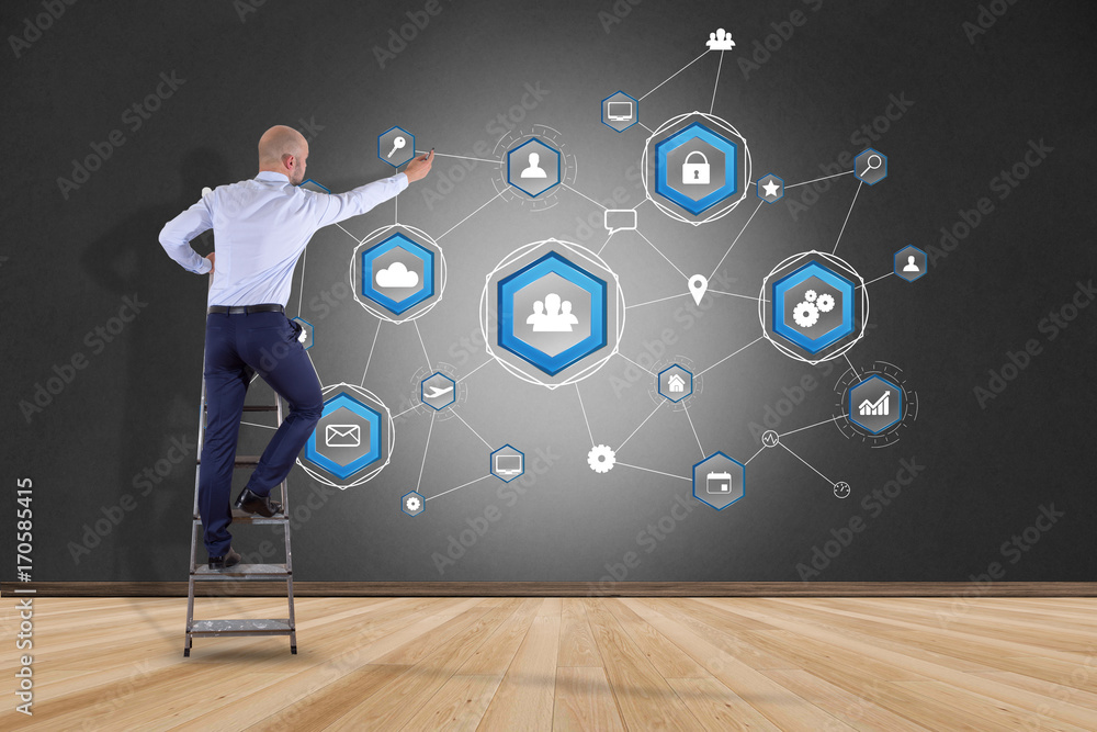 Poster businessman in front of a wall with a business network connection displayed on a futuristic interfac
