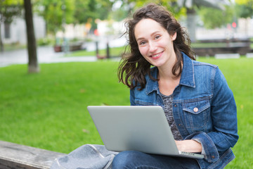 Portrait of a young student with backpack going to school and using her laptop - Technology and education concept