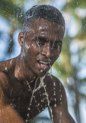Photo shoot for a black handsome guy, water runs down the face and body