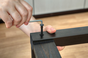 Screw furniture screw into wood plank using the hex key.