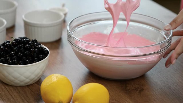 Egg whites in a glass bowl, beaten with sugar to stiff peaks.