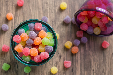 Jujube colored balls in a colorful glass bowl on a table top view