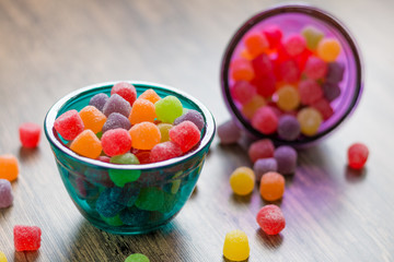 Jujube colored balls in a colorful glass bowl on a table