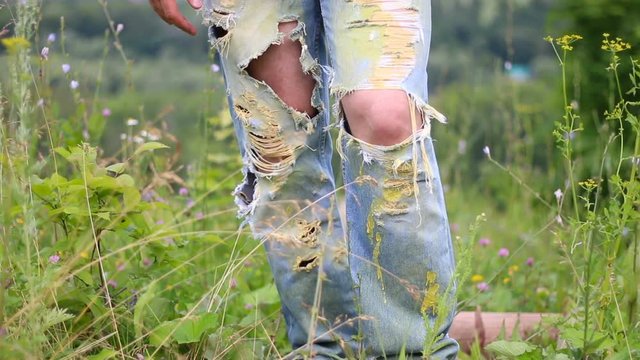 Male legs in ripped denim jeans outdoor