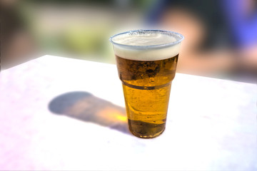 A glass of light beer on a white table
