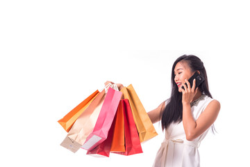 Cheerful shopping woman of Asian holding bags. Shopping smart business woman happy smiling holding colorful shopping bags with smart phone isolated on white . Fresh young Asian female model