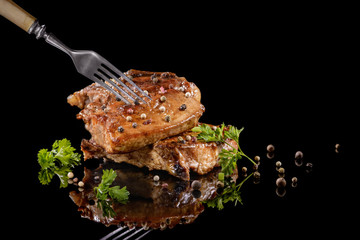 Fried meat on the fork with pepper