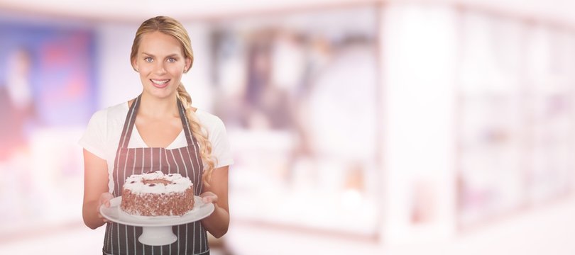 Composite image of portrait of young woman holding cake