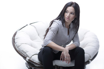 Fototapeta premium Young woman sitting in a round cozy soft big chair.