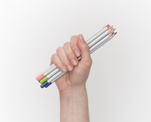 Female hand holding color pencils on a white background