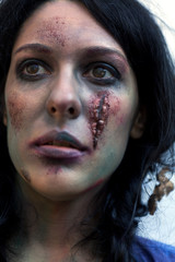 young zombie girl with traces of facial decomposition