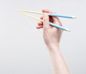 Female hand holding chopsticks, isolated on the white