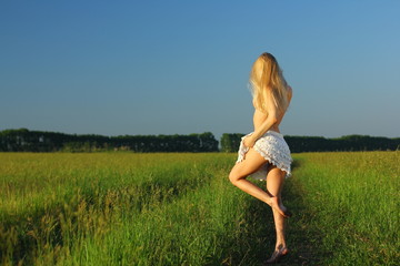 Young happy topless woman have fun in green summer field. 