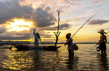 Fototapeta premium Asian boy and girl playing in the river with fisherman, in the morning sunrise, Thailand