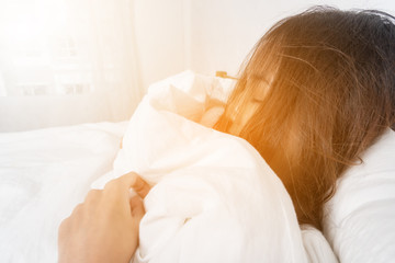 Closeup of Portrait of beautiful teenage female sleeping on white bed.