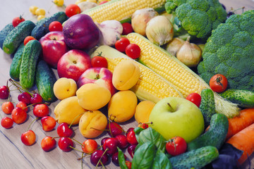 Autumn harvest vegetables. Vegetable composition. Fresh vegetables: broccoli, carrot, corn, cucumber, garlic, potatoes, salad, tomato, basil. Organic Vegetables. Fruits: cherry, peaches, apricots.