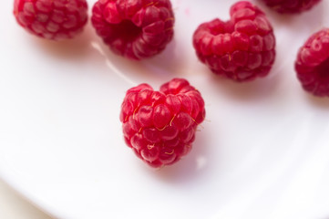 raspberries on a white saucer close up